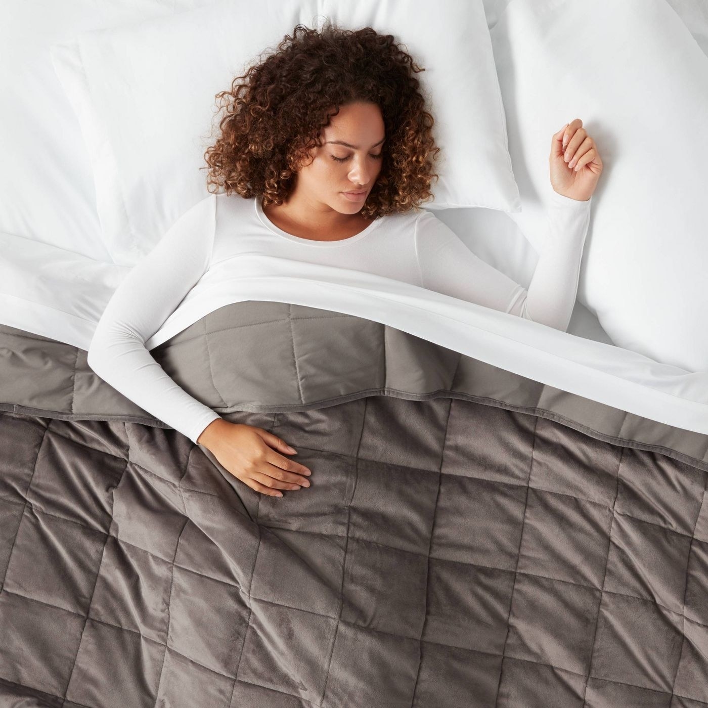 The weighted blanket, which has box stitching, in gray