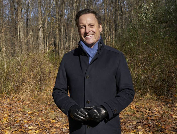 Chris Harrison standing in the woods wearing a winter coat, blue scarf, leather gloves