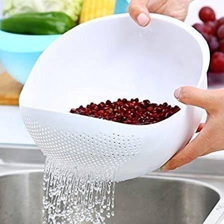 A pomegranate being washed using the strainer 