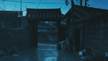 A mysterious gate stands open during a rainstorm 