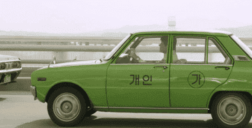 Song Kang-ho laughs as he drives a taxi