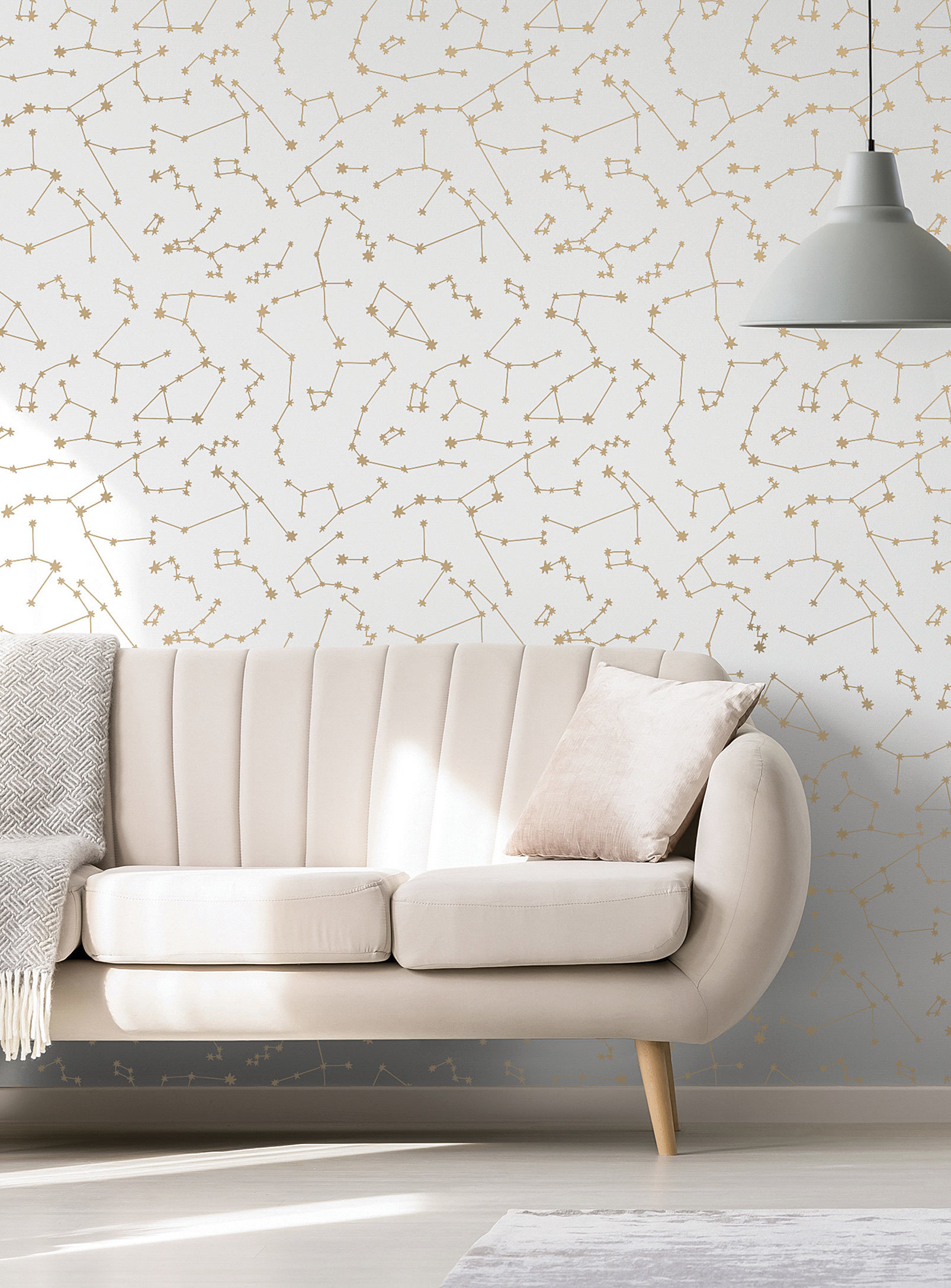 A couch in front of a wall with constellation patterns on it