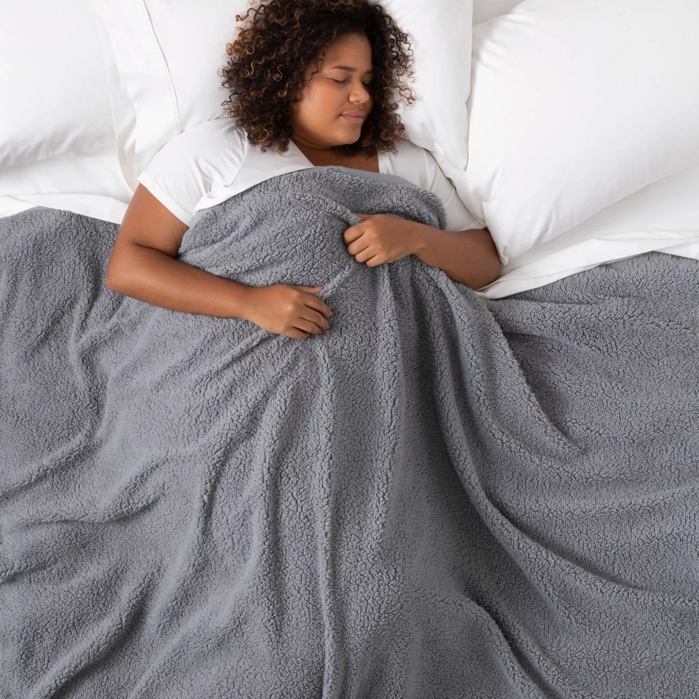 A model sleeping under the blanket in gray