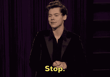 A gif of Harry Styles on a late night talk show playfully saying &quot;Stop&quot;