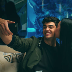 Lara Jean and Peter posing for a photo while at a party