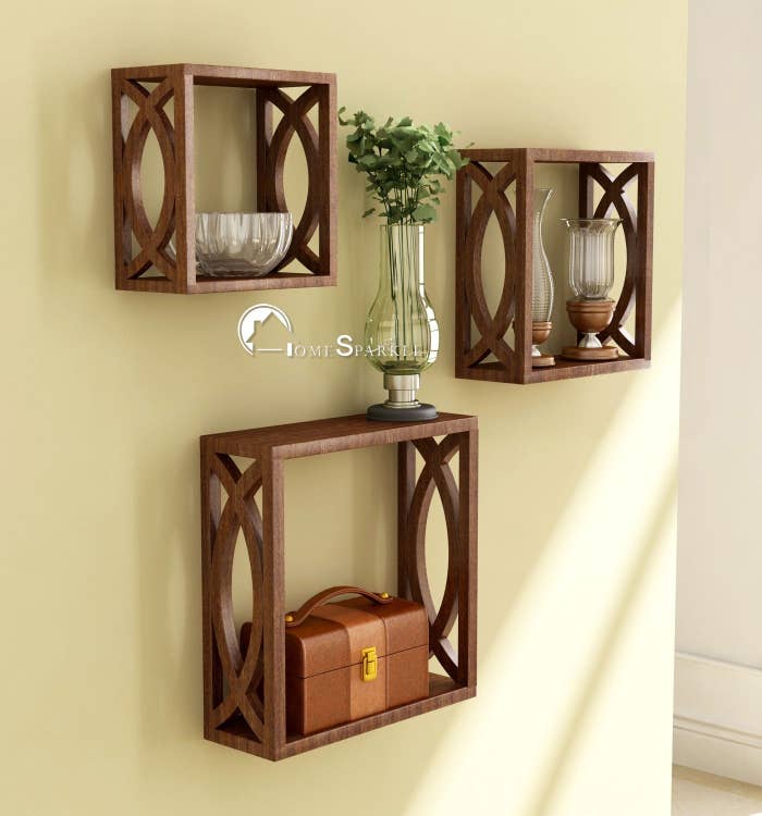 Cubical wooden shelves used to hold glass bowls, lamps, and a small trunk