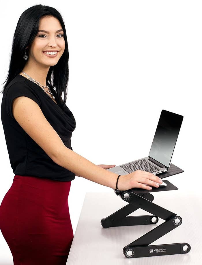 Model using a laptop on an adjustable standing desk