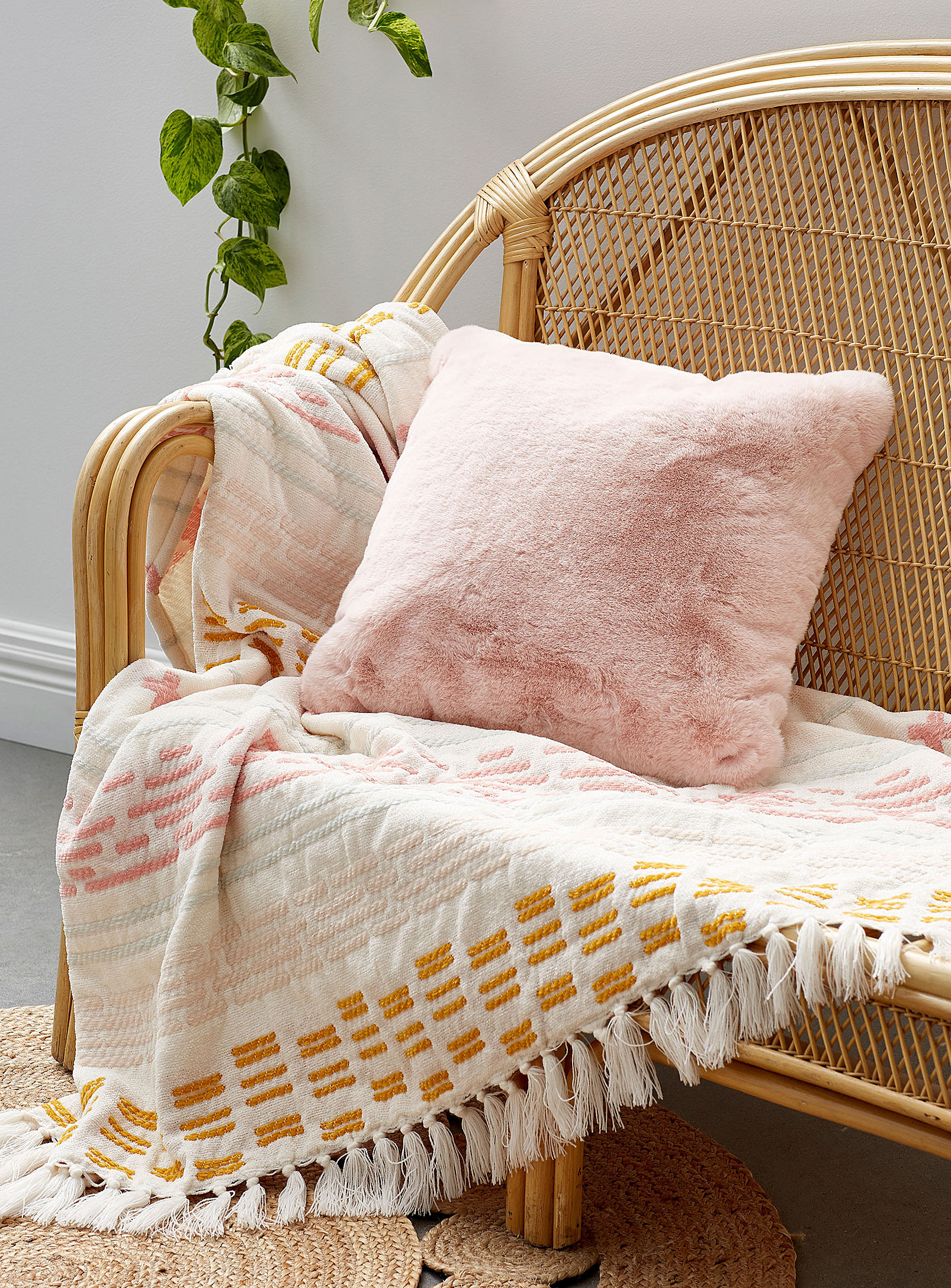 the soft pillow on a couch with a throw