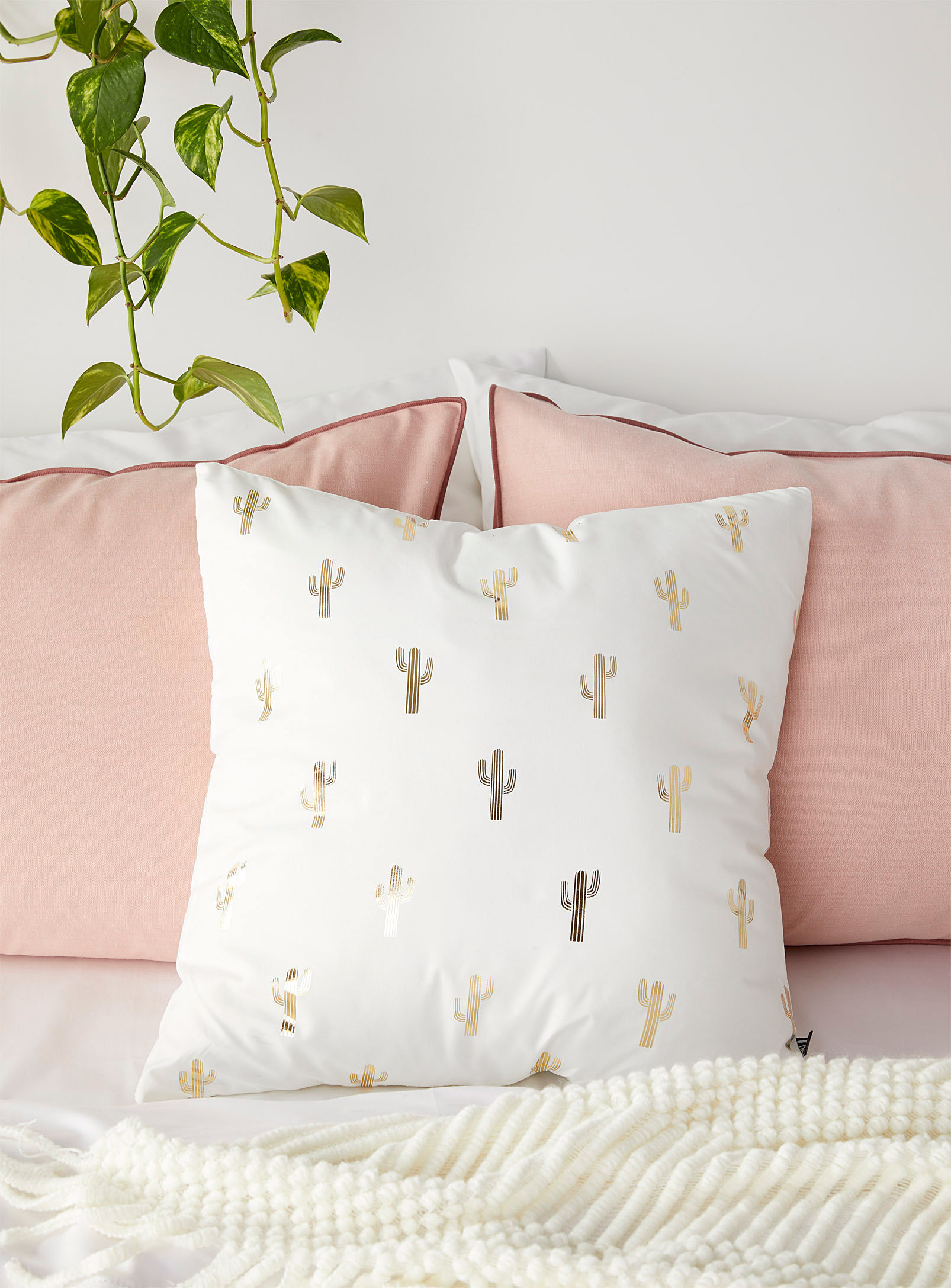the cactus pillow on a bed as an accent pillow