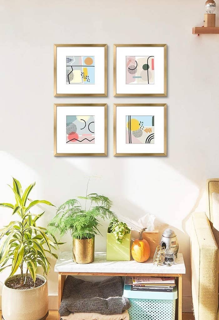 the four frames with the abstract prints inside on the wall