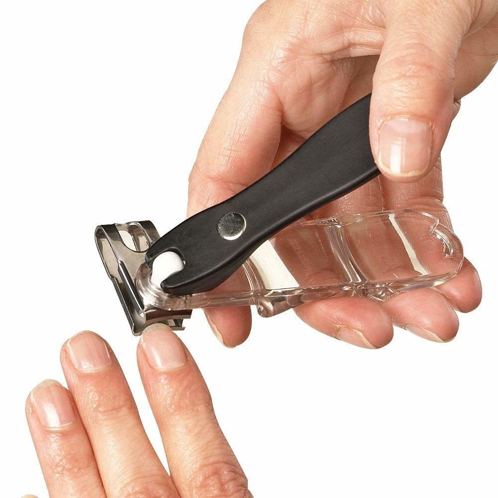 a model using the black nail clipper to trim their nails