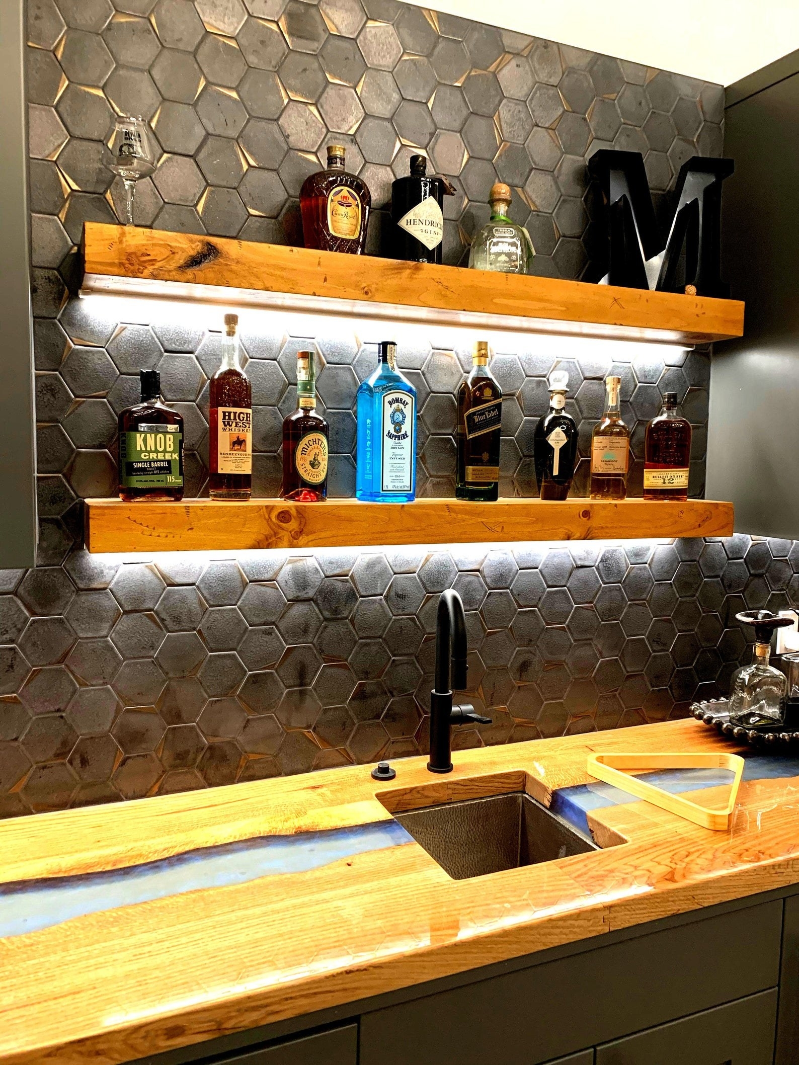 the floating shelves with alcohol bottles