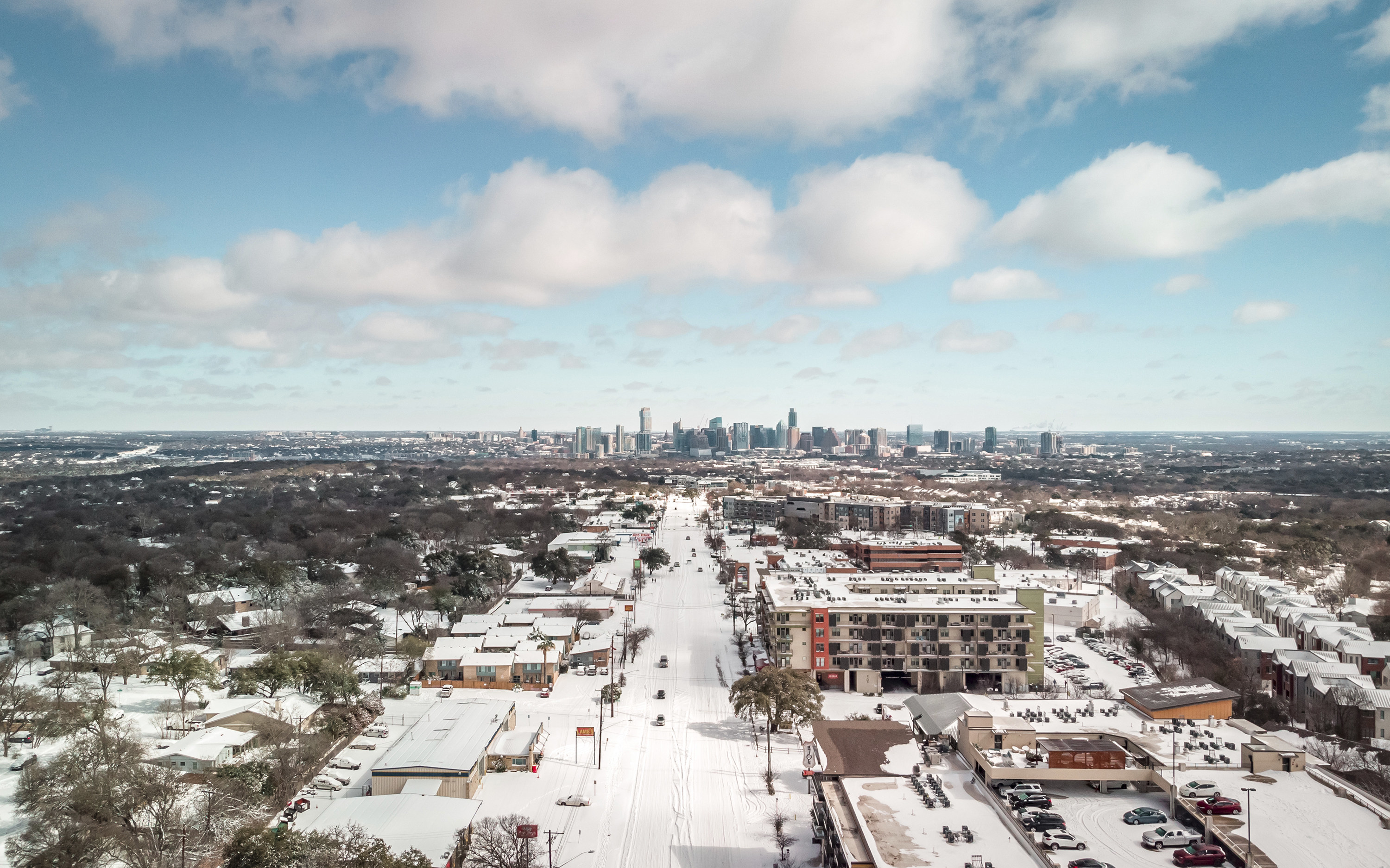 A snowy overhead scene in Austin showing snow-covered streets and a few cars