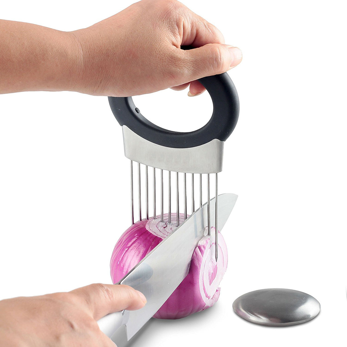 a hand chopping an onion held in place by the stainless steel holder