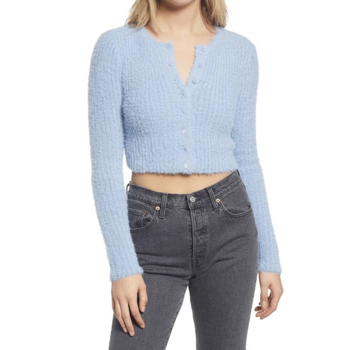 Model is wearing a light blue fuzzy crop cardigan and dark skinny jeans