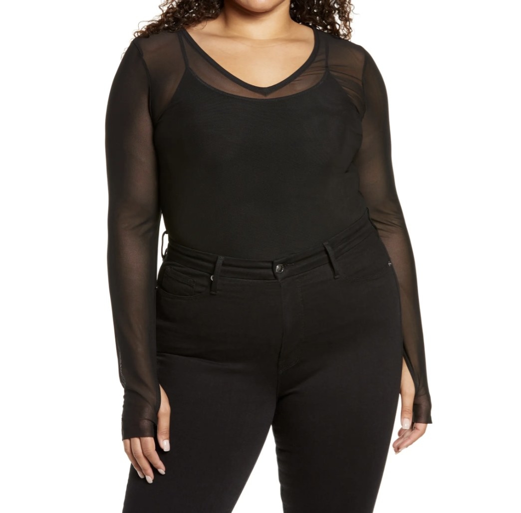 Model is wearing a black mesh top over a black tank and black pants