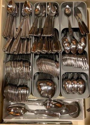Several utensil holders side-by-side with tons of utensils in the individual slots 