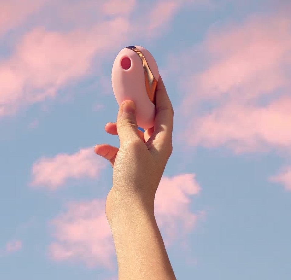 hand holding the light pink toy