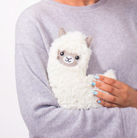 A person hugging a llama shaped heating pad