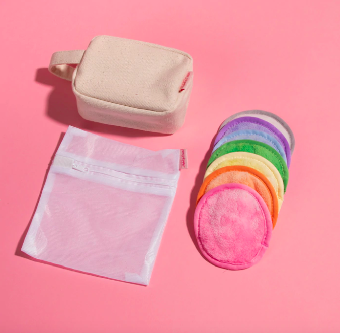 The seven-piece set arranged on a simple background next to the included laundry and makeup bags
