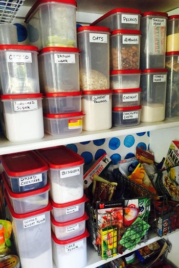A reviewer photo of a pantry filled with food storage containers each labels with the erasable labels 