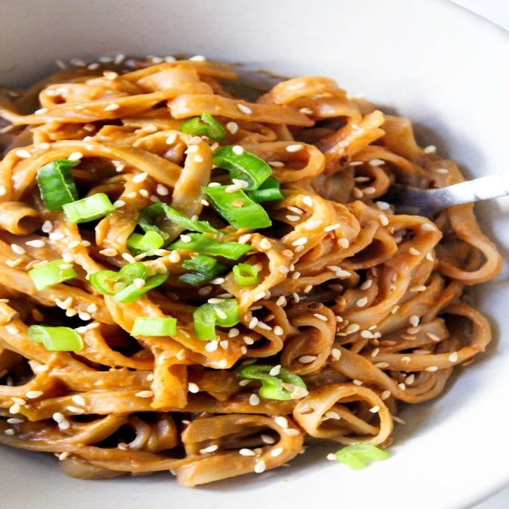 Peanut noodles with scallions and sesame seeds.