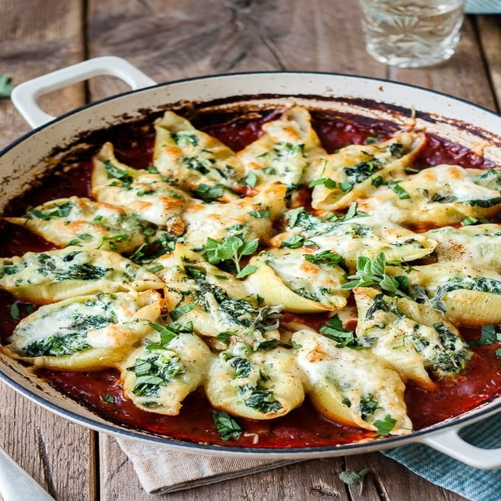 A pot of spinach and cheese stuffed shells in tomato sauce.