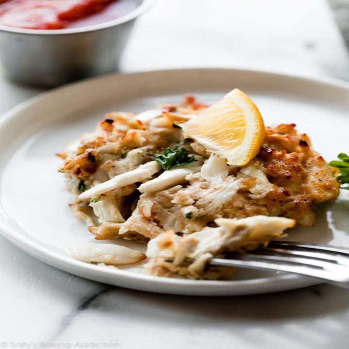 A crispy crab cake with a bite taken out of it.