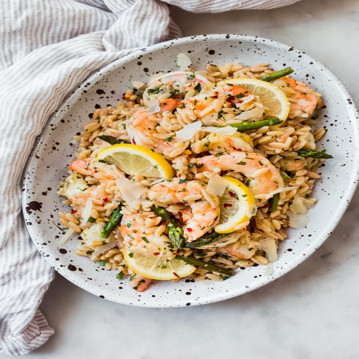 A plate of shrimp scampi over orzo.