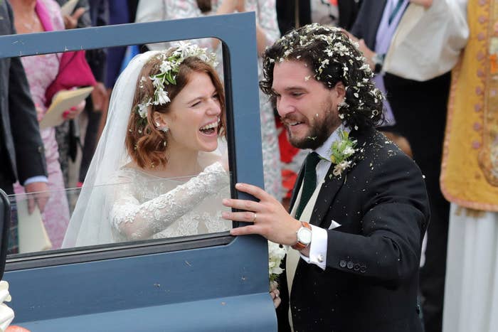 Kit and Rose smiling as they're about to get into a car on their wedding day