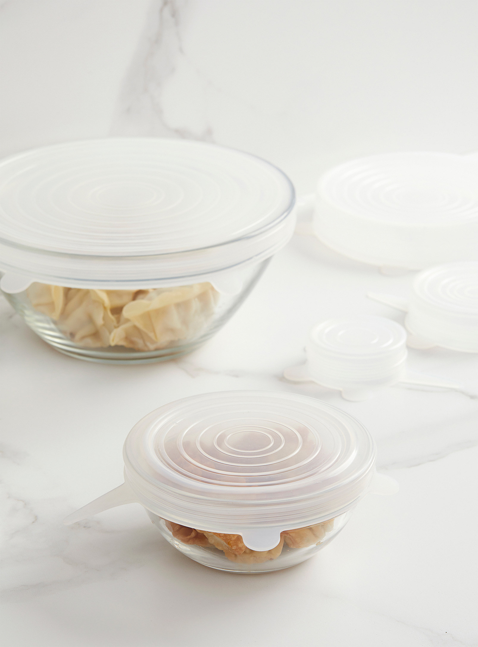 Two glass bowls of different sizes with silicone covers on them