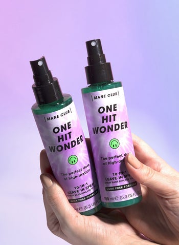 hands holding two of the spray bottles of leave-in conditioner