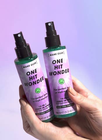 hands holding two of the spray bottles of leave-in conditioner