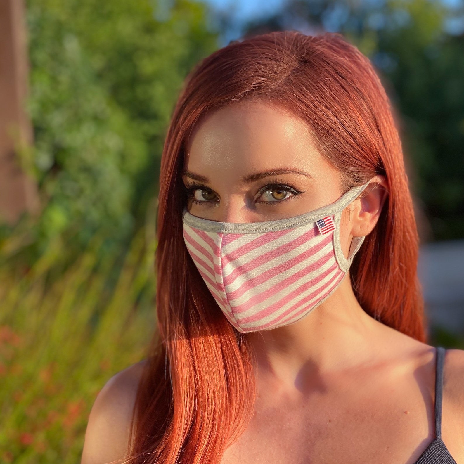 A model in a white and pink striped face mask 