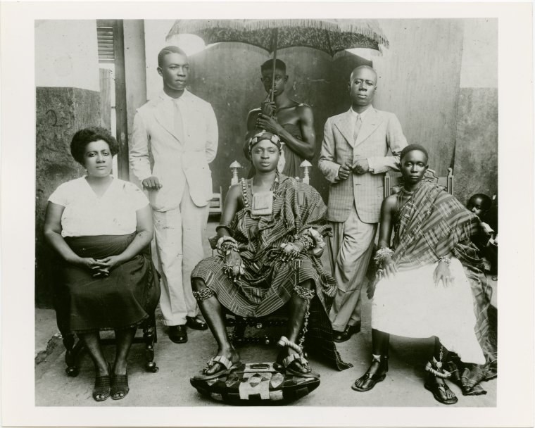 A group of six people sitting and standing, facing the camera