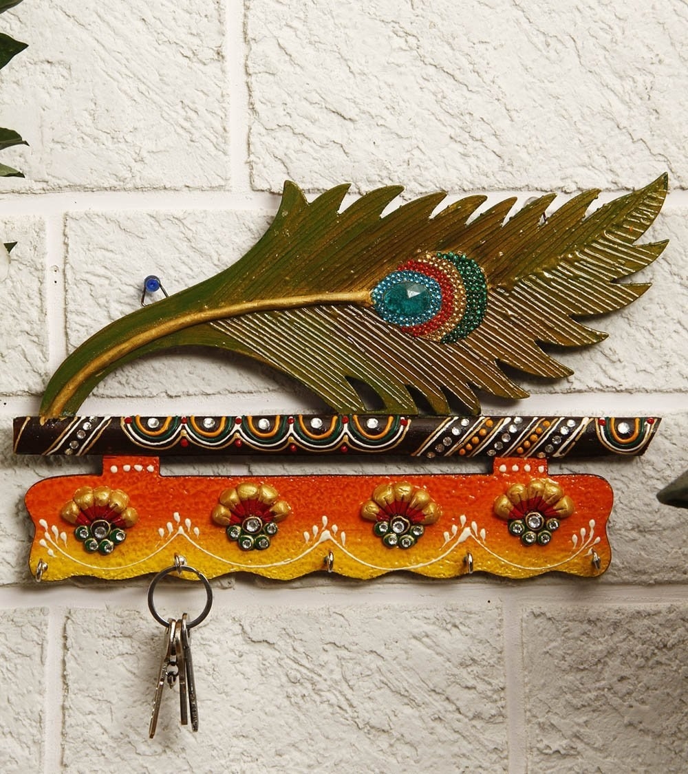 A peacock feather key holder on the wall