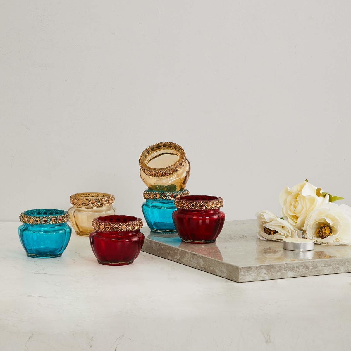Multicoloured tealight holders on a table
