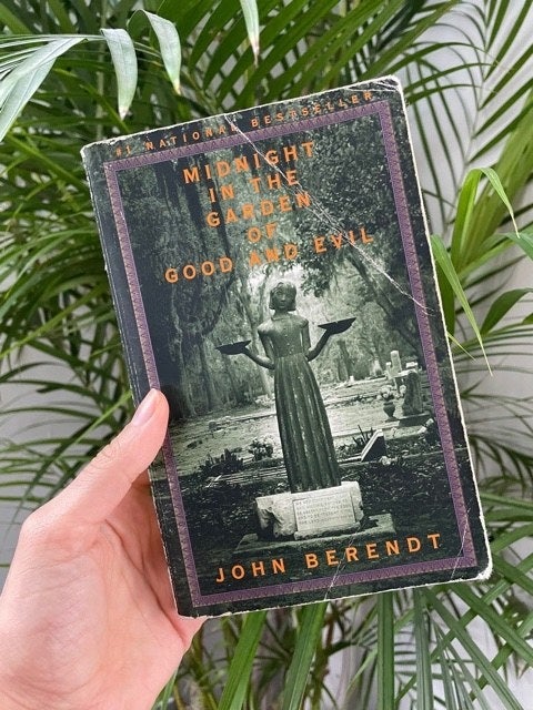 Someone holding Midnight in the garden of good and evil