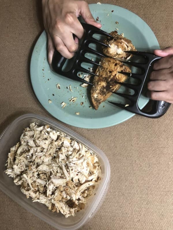 Reviewer using meat claws to shred chicken