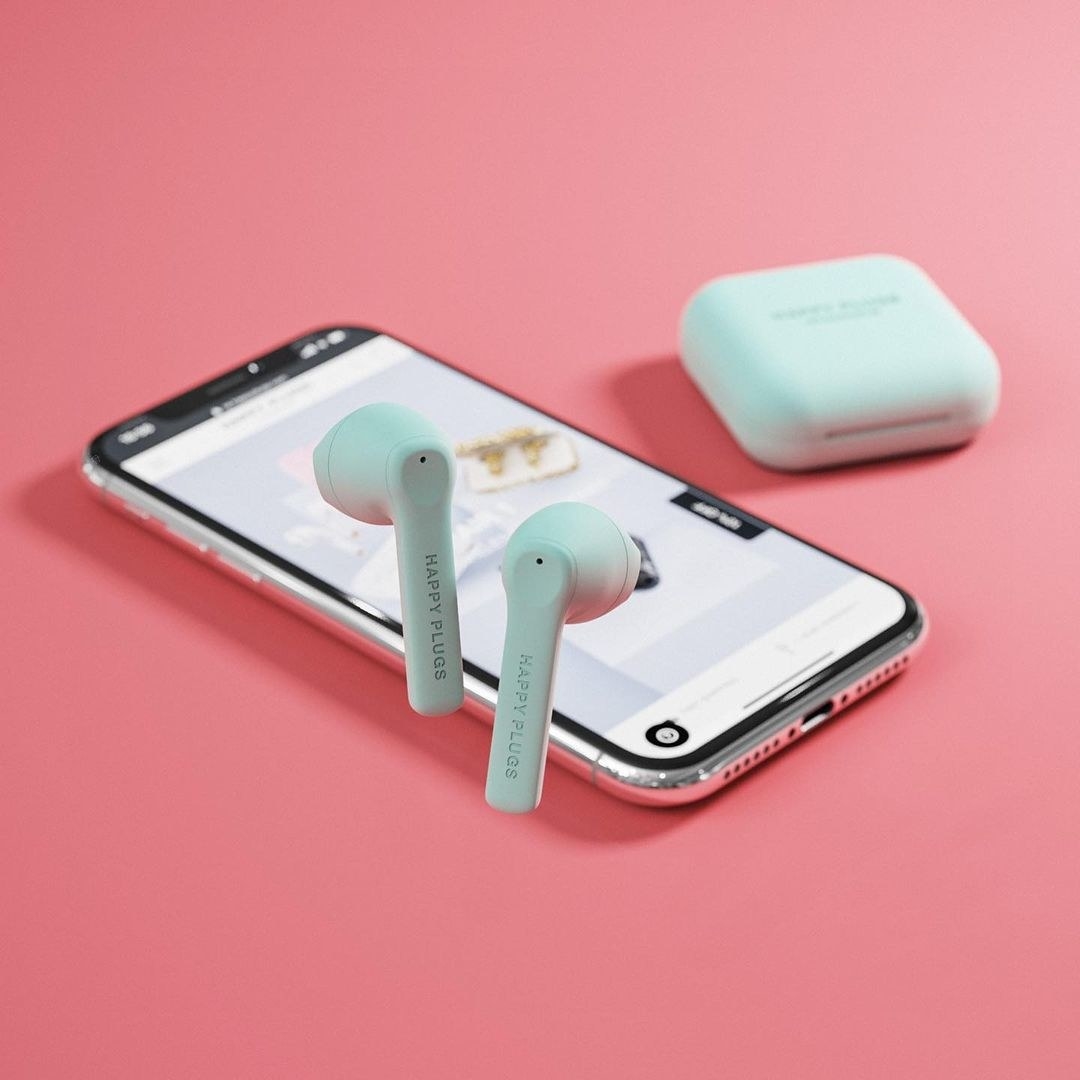 The mint green headphones in front of a phone