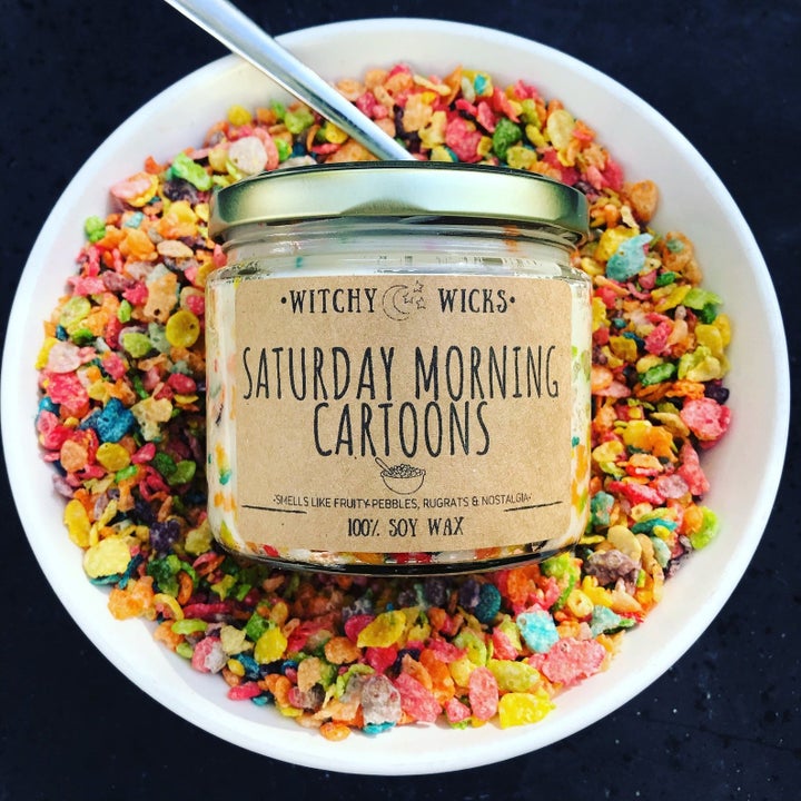 A candle that says "Saturday Morning Cartoons" resting on a bowl of Fruity Pebbles