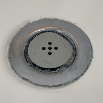 A reviewer photo of their tub drain with the gray TubShroom inserted 