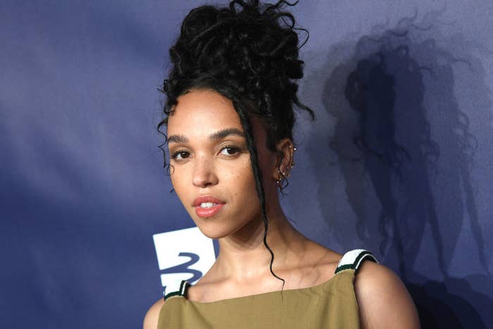 FKA Twigs posing at an event with her hair in an updo