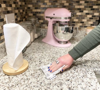 Model using reusable sponge to clean kitchen counter