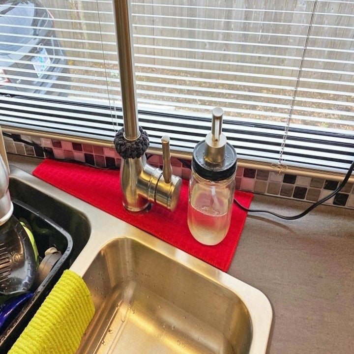 Red drip catcher placed around kitchen sink's faucet