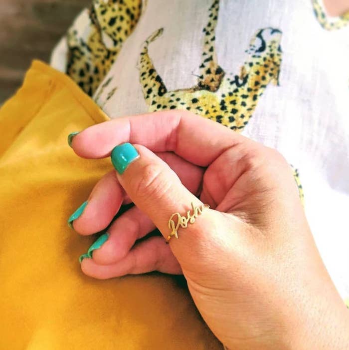 hand wearing the custom gold signature ring on their thumb