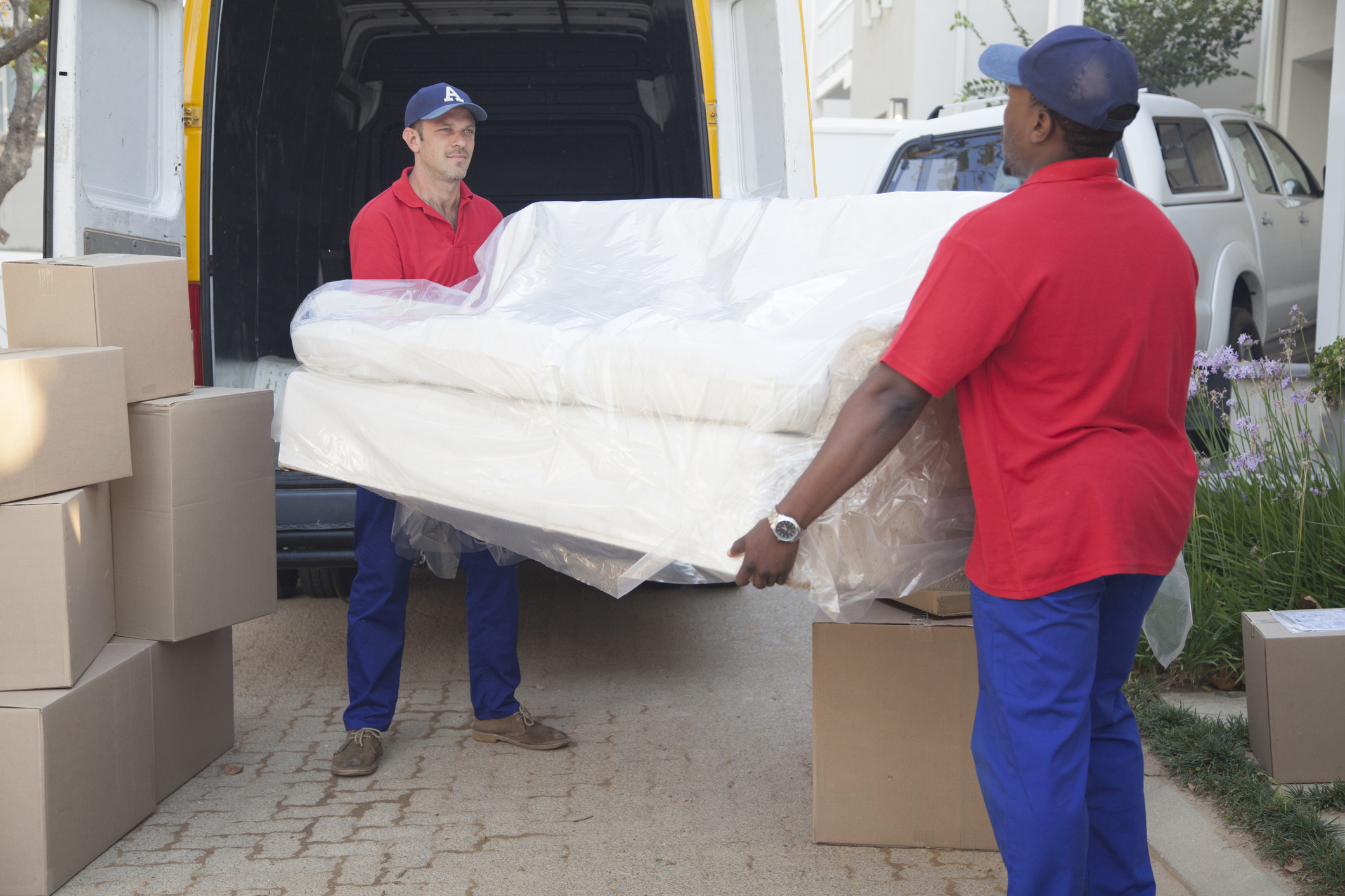 Two furniture movers carrying a couch