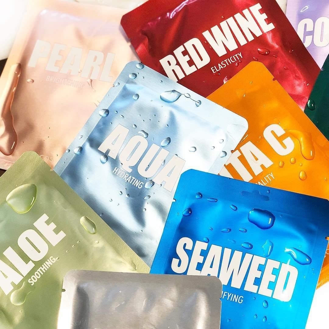 Several packets of the face masks arranged in an overlapping pattern and splashed with water