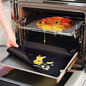 Liner being used to catch pizza melting spill in an oven