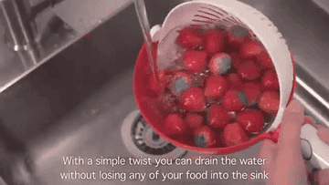 A GIF of a person rinsing strawberries and straining in the same bowl